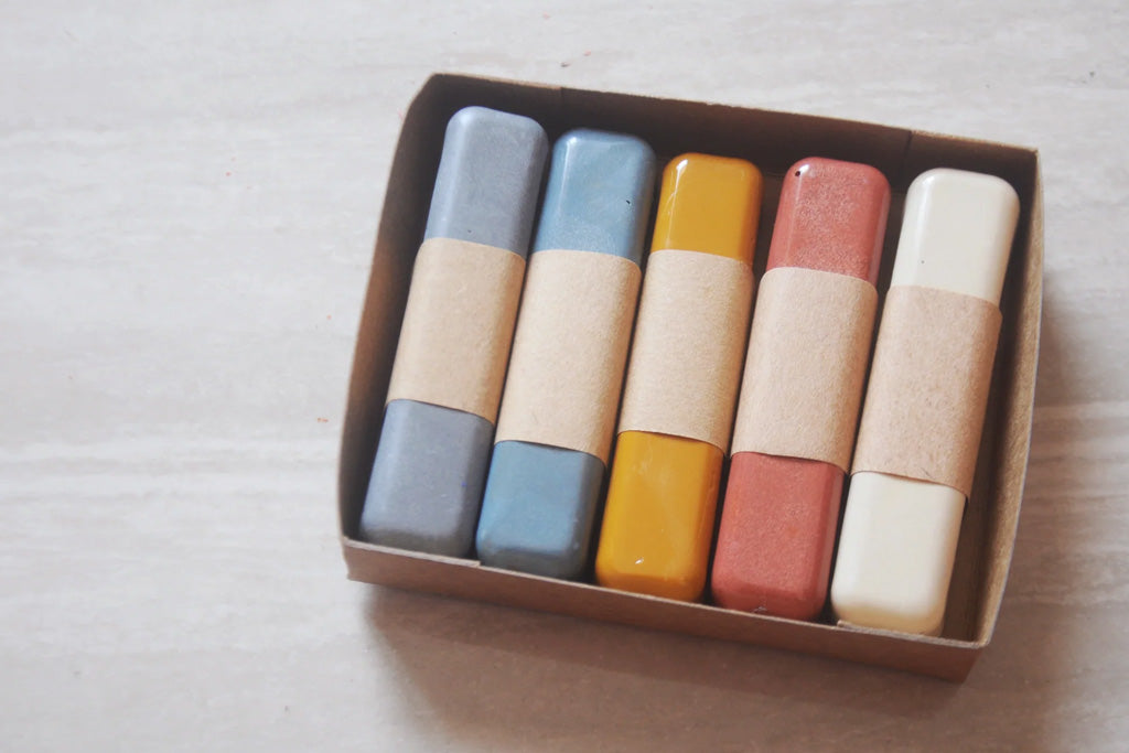 Set of five eco-friendly, non-toxic beeswax oil pastels in soft pastel colors, neatly packed in a recyclable kraft box