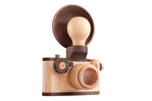 Vintage-inspired wooden toy camera with detachable light bulb flash, crafted from solid wood for imaginative pretend play.