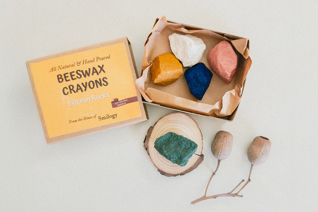 Box of hand-poured beeswax crayons shaped like ocean rocks in five colors, non toxic and eco-friendly perfect for young artists