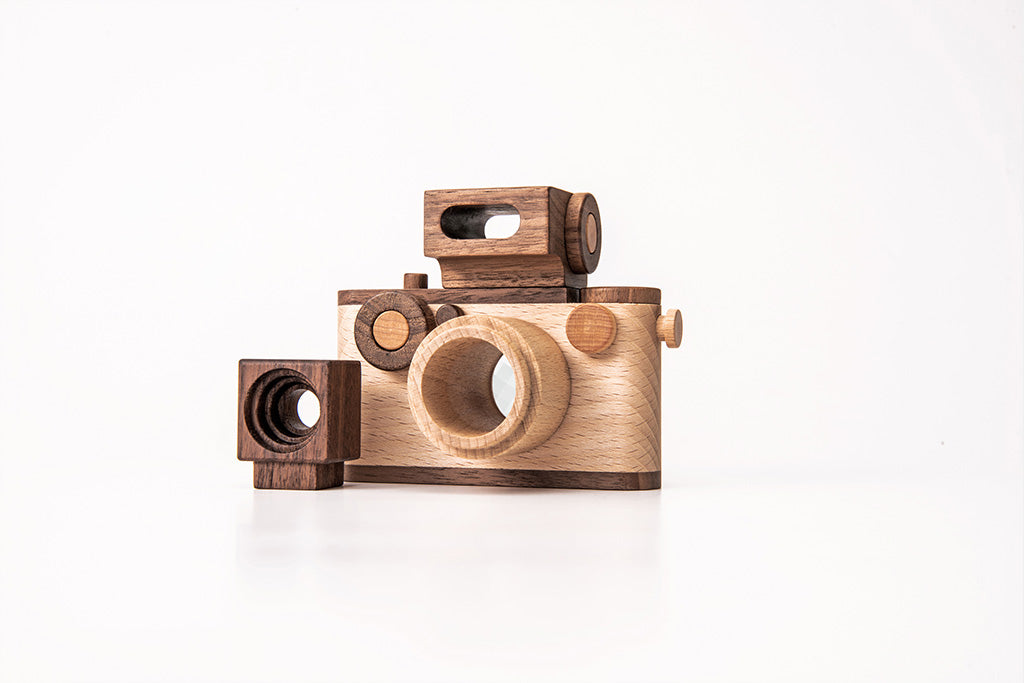 Father's Factory 35MM Original wooden toy camera made of walnut and beechwood, featuring a detachable magnetic flash, clickable button, and kaleidoscopic lens. Ideal for pretend play, sensory play, and homeschooling, this non-toxic, heirloom-quality toy meets all safety standards. Doubles as an eco-friendly decor item for children’s rooms.