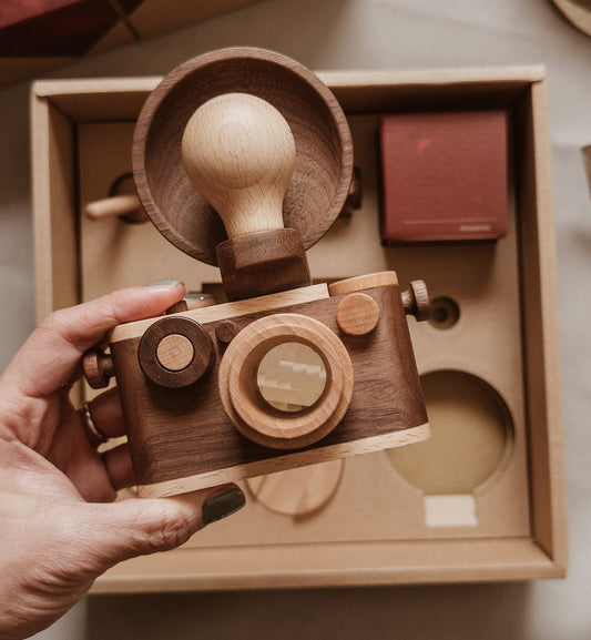 EXPERT Wooden Toy Camera Gift Set featuring a 35mm wooden camera, wooden tripod, and four wooden flashes; designed for creative play and home decor. Includes a kaleidoscopic lens and clickable shutter button, perfect for imaginative adventures with your little photographer. Durable construction ensures lasting fun and family enjoyment