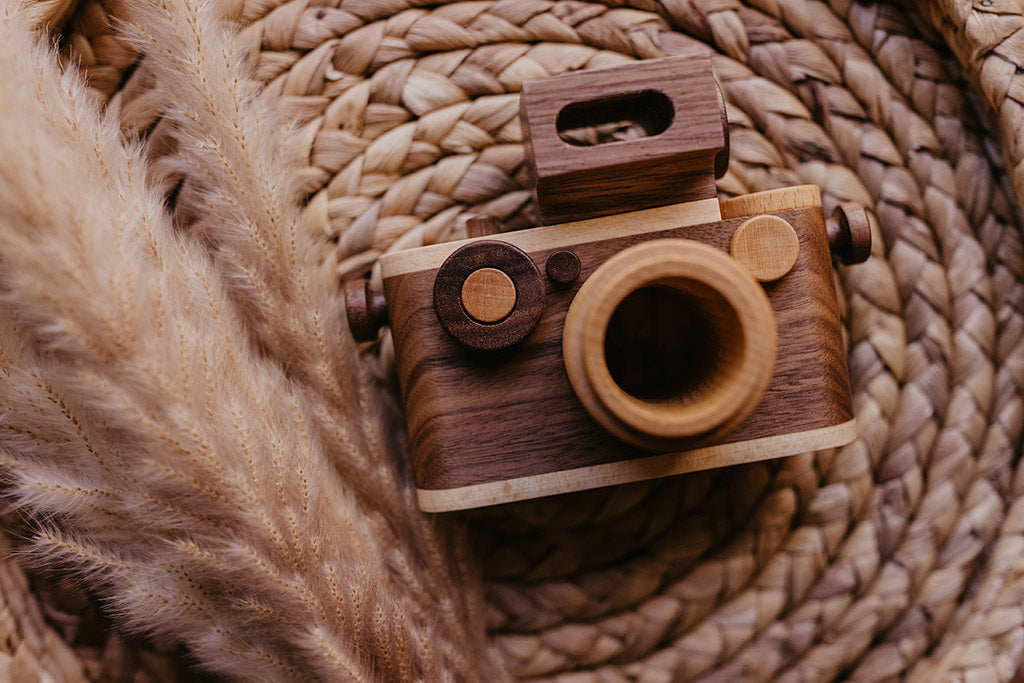 35MM camera style wooden toy camera with detachable magnetic flash, clickable button, and kaleidoscopic lens. It’s the perfect toy camera for pretend play, sensory play, and homeschooling. This camera for kids is made of walnut and beechwood with heirloom quality. Non-toxic wooden toys, child-led play wood toys, wooden toys for children, and environmental friendly toy. Tested To Meet All Safety Standards. The wooden toy camera can be an interior decor item for a kid’s room.